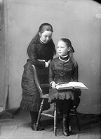 Portrait of two young girls reading