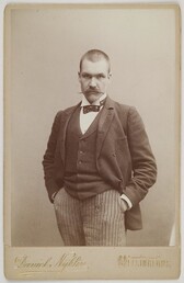 Photography studio portrait of Axel GallÃ©n staring at the wiever with his hands in his pockets, Helsinki, 1890.
