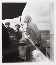 Akseli Gallen-Kallela with a pipe in his mouth, sculptor Alpo Sailo (the hand with a hammer on the left) and workers on the tower of TarvaspÃ¤Ã¤, 1927.