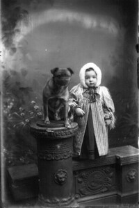 Portrait photograph of toddler with dog n.d.