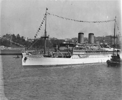 Dutch liner "Nieuw Zeeland" passing the moored HMAS "Canberra", Sydney Harbour Bridge opening, 19 March 1932 / Sam Hood