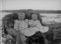Two children on a bear skin fur, Bowden, Alberta