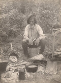Old man cooking outdoors, 1910