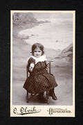 Portrait of a young girl with checkered dress sitting in a chair