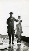View of foreman Angus McDonald with a Co-op salmon at Pacific Coast Fishermen's Union (P.C.F.U.) fish buying camp at Stuart Island Landing, B.C
