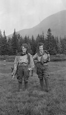 Two women on a trek with rifles and cartridge belts