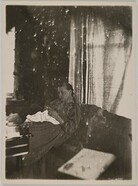 Mary GallÃ©n sewing, wearing a Carelian dress; print 2 of the photograph.