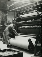 British rubber workers in Lancashire spreading machine for coaling canvas for tire making