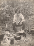 Old man cooking outdoors, 1910