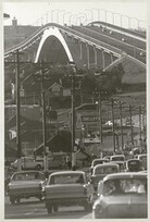 Traffic and line of telegraph poles approach the Gladesville Bridge, Oct 1966