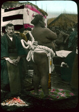 Men preparing for sumo wrestling outdoors.