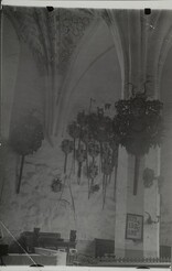 Interior photograph of a Medieval church, family crests hang from the wall