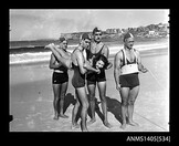 Woman modelling swimwear, with lifeguards in 1949