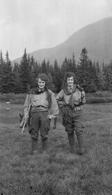 Two women on a trek with rifles and cartridge belts