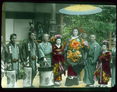People in special attire, with lanterns, posing for photograph.