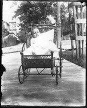 Baby in wicker stroller n.d.