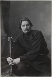 Portrait of Maxim Gorky sitting in an armchair wearing a dark shirt.