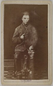 An arrested man in chains sitting in a chair in Pori in the late 19th century.