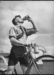 Rider carrying spare inner tubes, 'Thousand Mile Cycle Race', New South Wales, 10 October 1945, Alec Iverson
