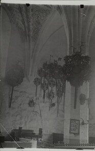 Interior photograph of a Medieval church, family crests hang from the wall