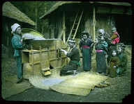 Rice being poured into a wooden mechanical hopper.