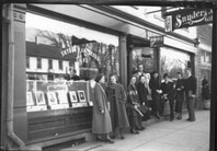 Group of people on sidewalk in front of Snyder store 1936