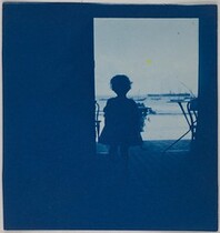 Child standing in the doorway of a seashore house.