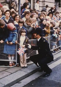 Policeman & child outside Grimsby Town Hall, awaiting arrival of Her Majesty The Queen 1977 (archive ref CCHU-4-1-9-2)