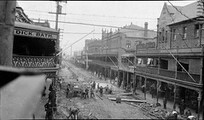 Workmen laying concrete paving, Hunter Street, Newcastle near the Hotel Rawson and premises of Dick Bath, ca. 1921, Sam Hood