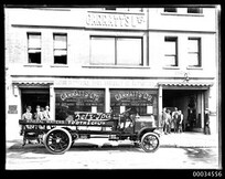 Tooth and Company Fiat drinks delivery truck in front of Garratt's Ltd showroom and garage