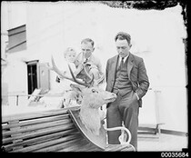 Two men and a child looking at a mounted deer head on board SS ORUNGAL, c 1930