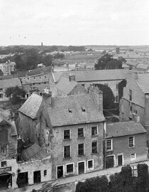 Elevated view of buildings in a town, one of the buildings has the sign "Thomas Hart, Marine dealer"