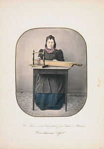 A woman sitting by the table with a "langleik" in front of her, Slidre in Valdres
