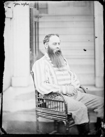 Portrait of Lord Alan Spencer-Churchill seated and wearing a striped shirt