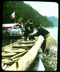 Two boats on river, a passenger boat being poled and a fishing boat filled with lidded open work baskets.