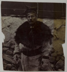 A man dressed in fur with a four winds hat on his head.