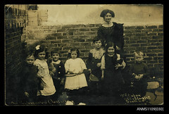 Photographic postcard of a female teacher with her kindergarten class at Miss Capon's Private School in Southsea, Portsmouth