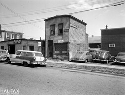 Former Charles St. Barber Shop, 38 Charles St., showing Sutherland's Auto Body Shop in the background
