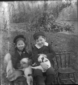 Boy and girl with puppies n.d.