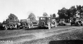 Parked cars and gathered crowds at an unidentified location - possibly Point Pleasant Park