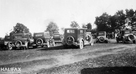 Parked cars and gathered crowds at an unidentified location - possibly Point Pleasant Park