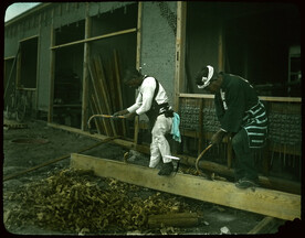 Men trimming edge of a plank.