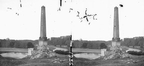 Square obelisk by footbridge with iron railing over wide stream, woods in background, Drogheda