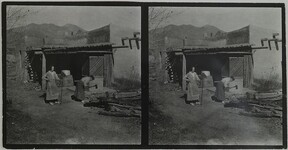 Mary Gallen-Kallela cutting wood with daughter Kirsti watching at home in Taos, New Mexico, ca.1925.