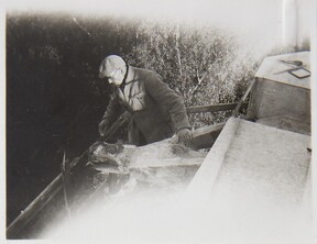 Akseli Gallen-Kallela on the tower of TarvaspÃ¤Ã¤ working on a dragon-shaped gargoyle, 1927; photograph 4.