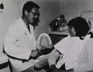 PHS dentist demonstrates proper tooth-brushing procedure to a young female patient