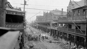 Workmen laying concrete paving, Hunter Street, Newcastle near the Hotel Rawson and premises of Dick Bath, ca. 1921, Sam Hood
